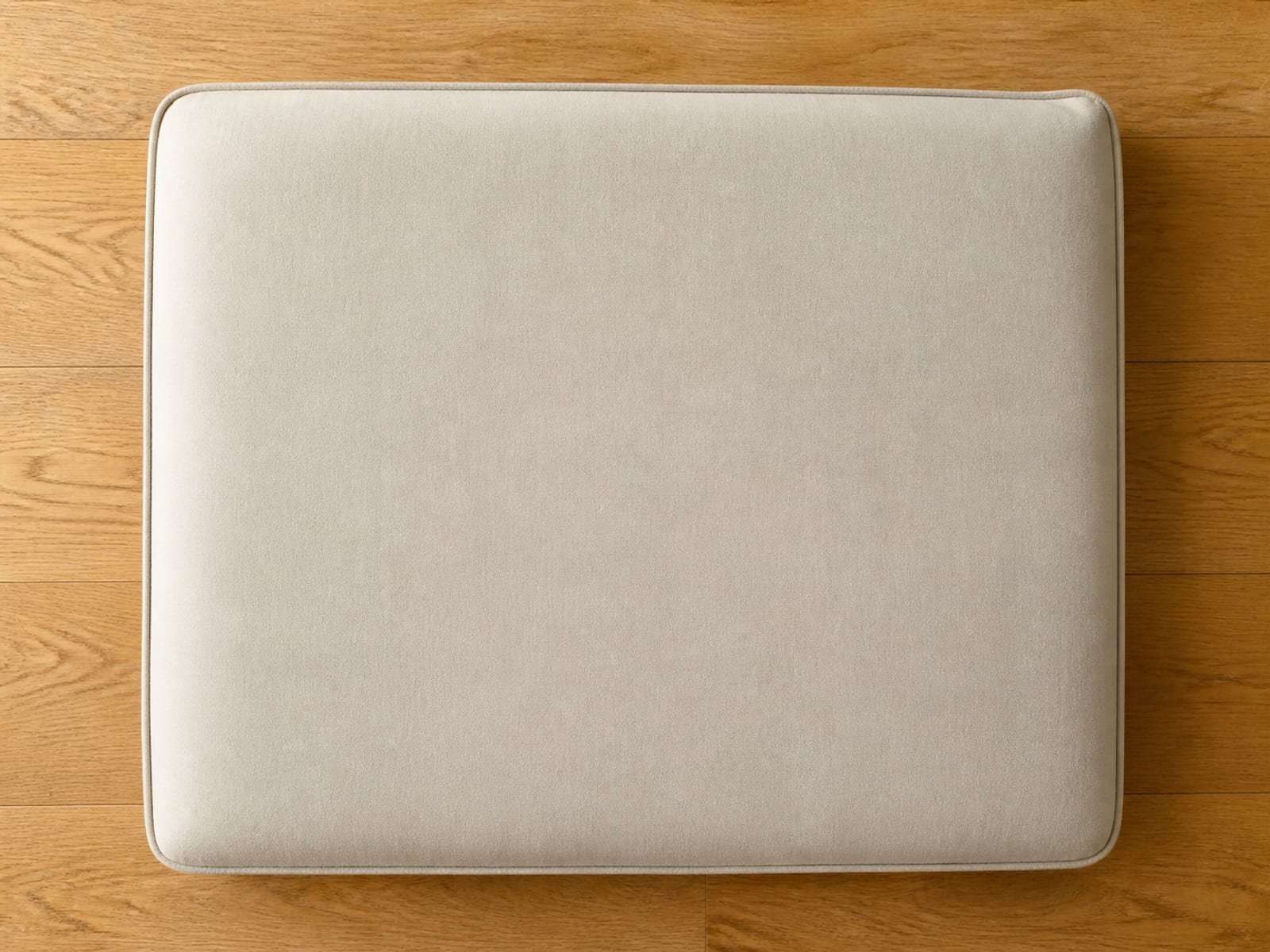 A single microfiber seat cushion laid flat on floorboards, its pile brushed evenly so the whole face is one continuous tone