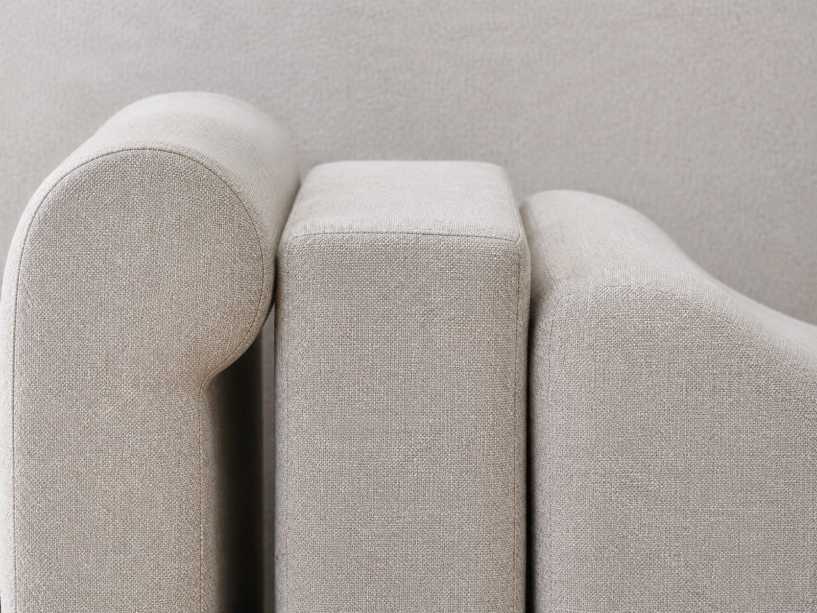 Three sofa arms of clearly different profile side by side in one identical pale fabric, cropped so only the arms fill the frame: rolled, square and low curved