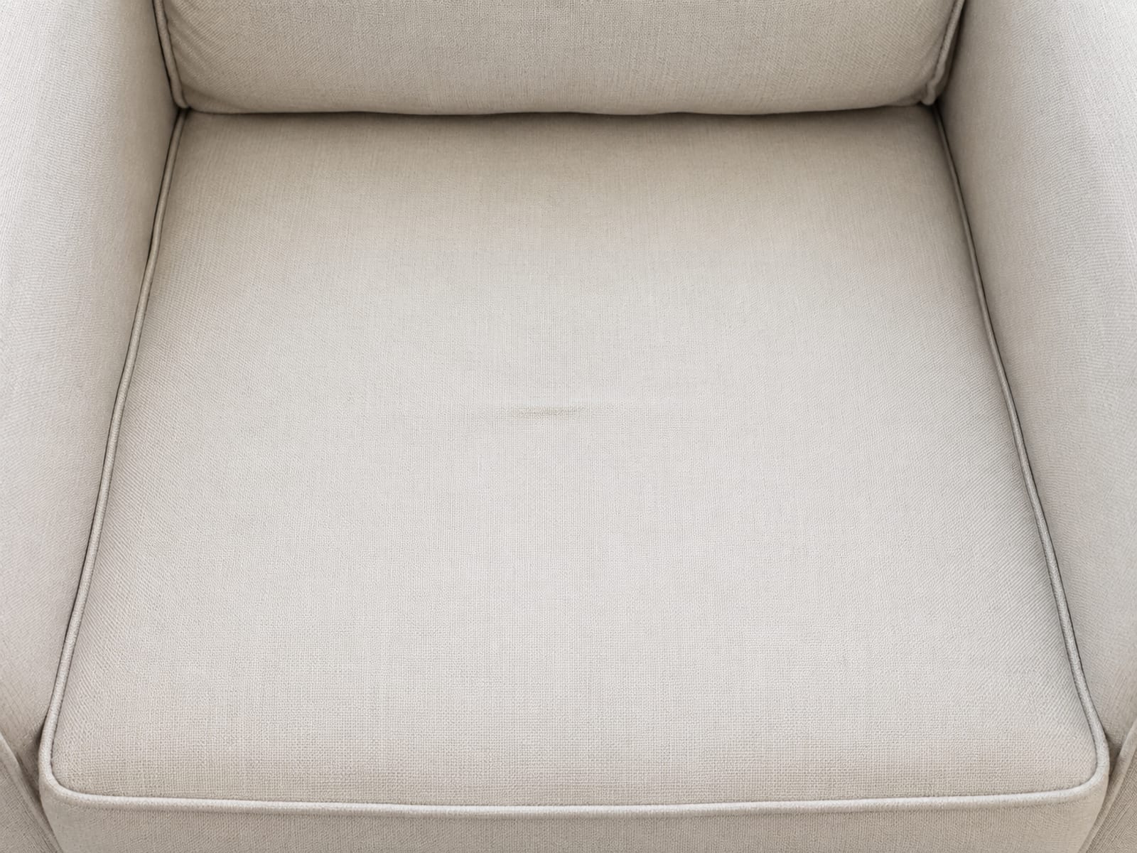 A close view straight down onto the seat of a deep upholstered accent chair, the whole seat surface running from the front edge to the base of the back cushion
