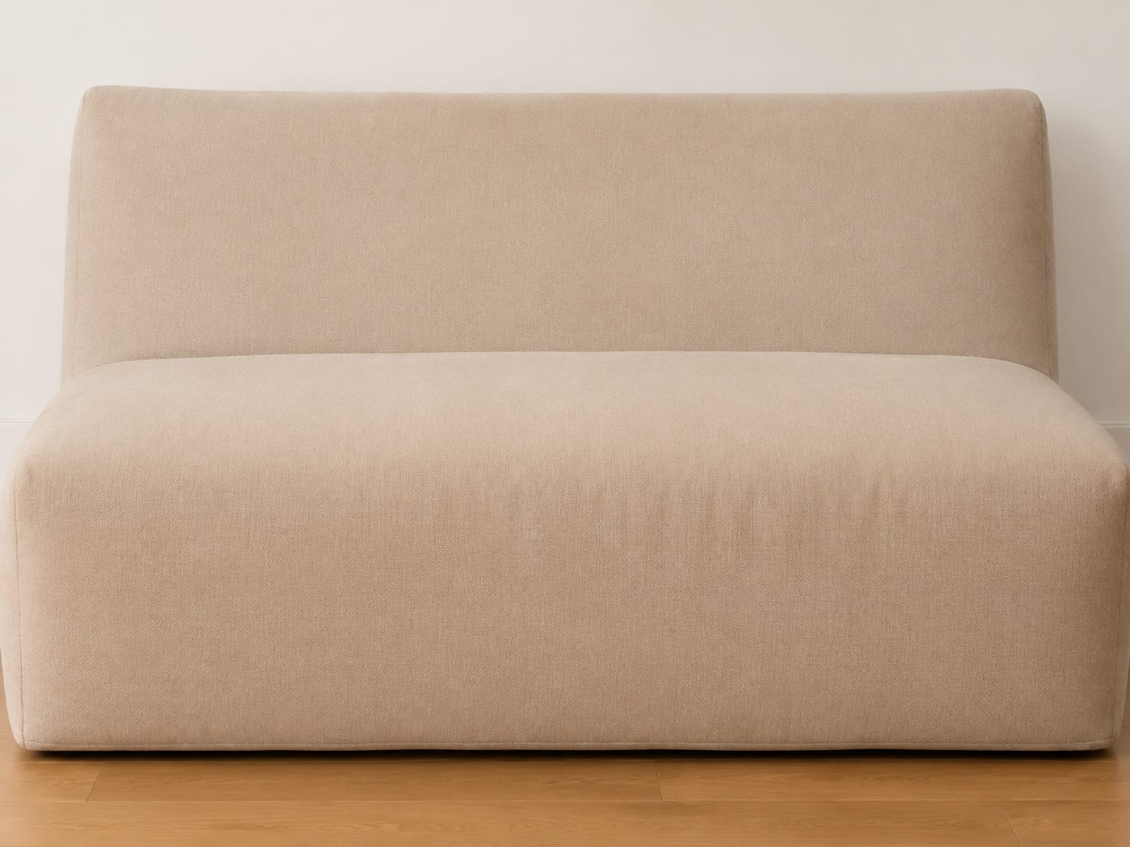 One very large boneless seat unit photographed square from the front at seat height, filling the frame edge to edge with a narrow band of plain wall above and bare floor below