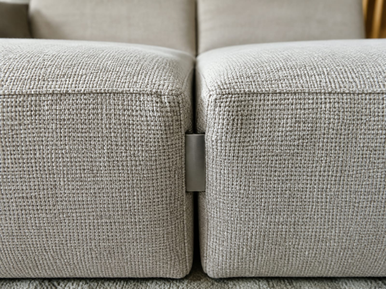 The vertical join where two modular seat units meet, the small gap and the connecting bracket visible between the fabric edges