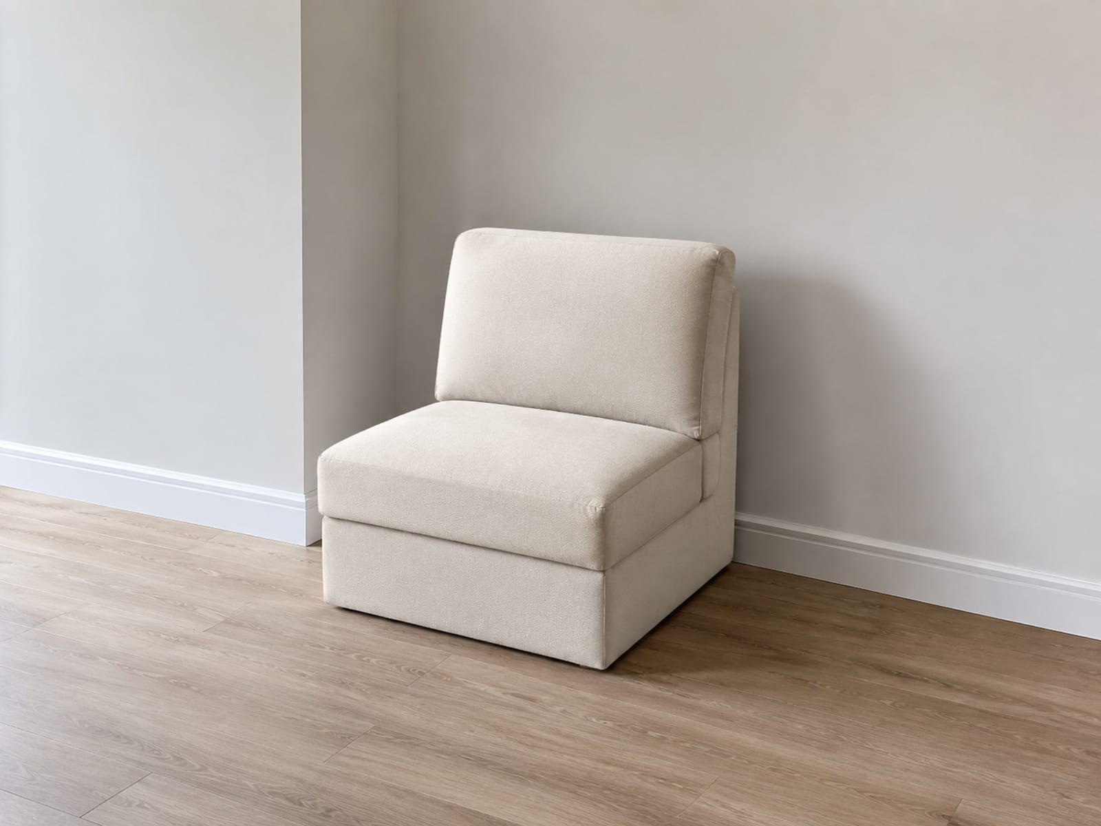 A sleeper chair fully closed in its seating position in the corner of an empty room, seen from standing height at a three-quarter angle