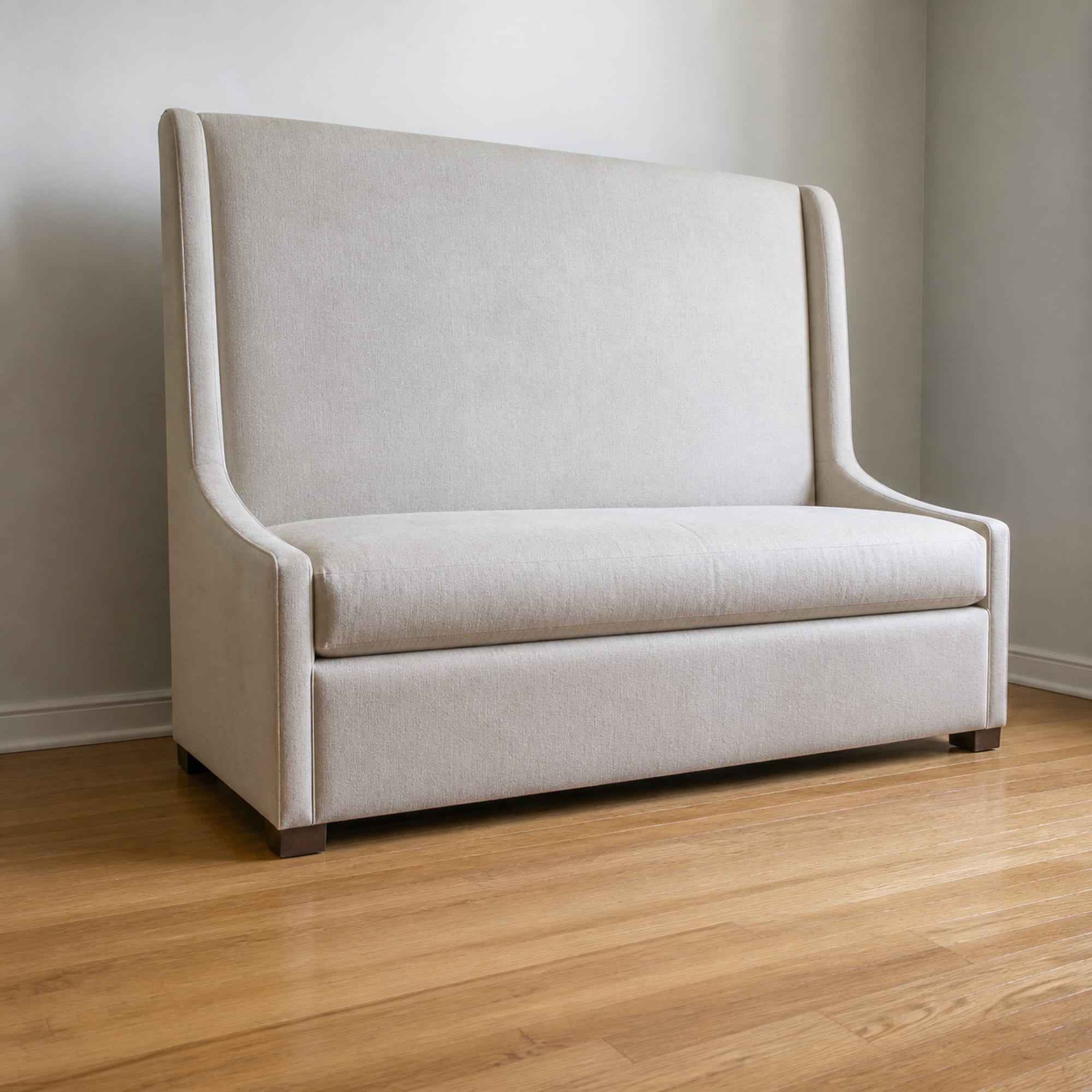 A sofa with an unusually tall upright back standing alone against a plain wall, photographed from a low front three-quarter angle so the back rises high in the frame