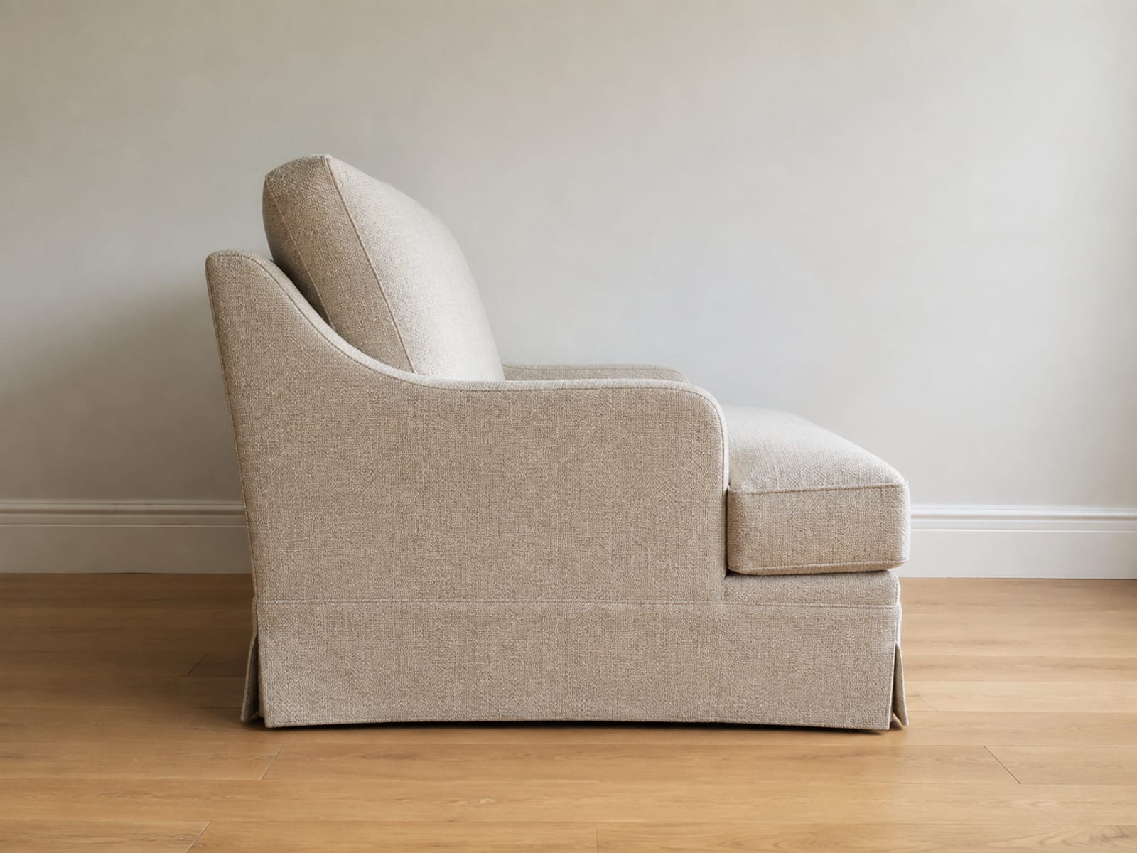 A two-seat loveseat photographed square from the side at seat height, its seat reaching well forward from the back cushion